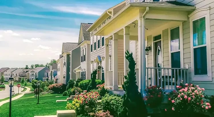 A row of townhouses with well-maintained lawns and landscaping, representing suburban living.