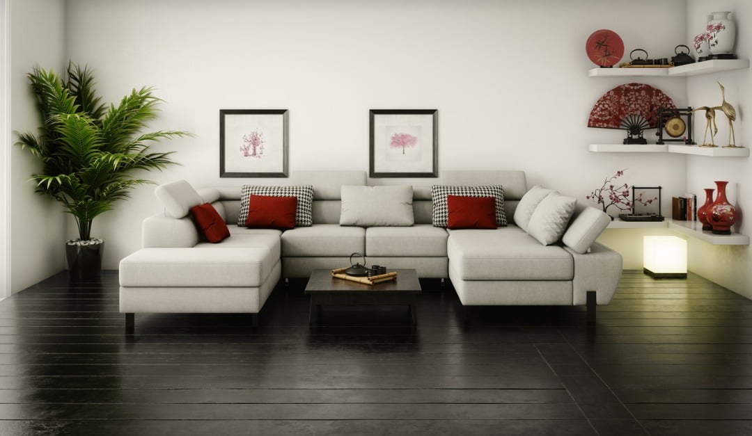 Furnished living room with a light-gray sectional, red accent cushions, dark hardwood floors, and display shelves.