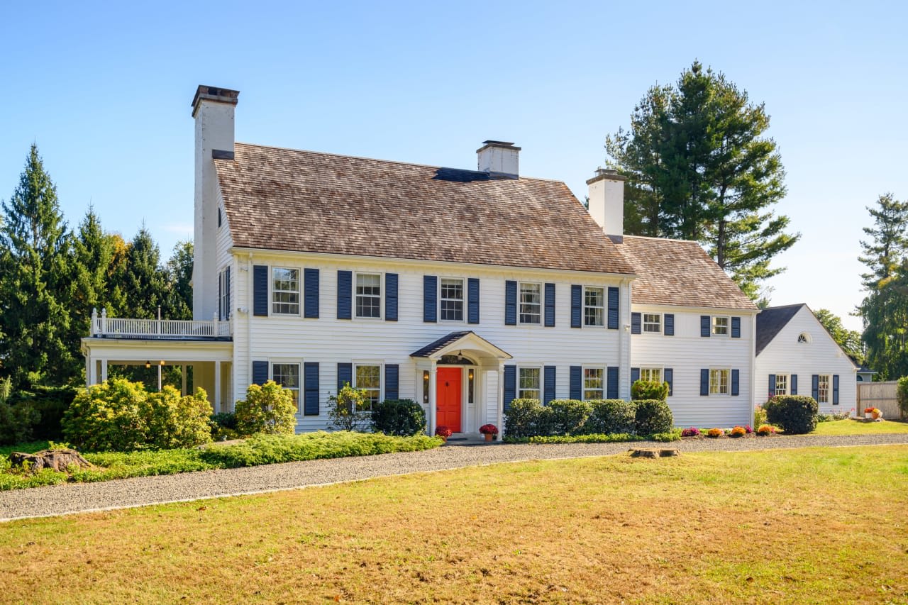 An Antique House building in 22 Currituck Newtown, Connecticut, with a red brick exterior, white columns.