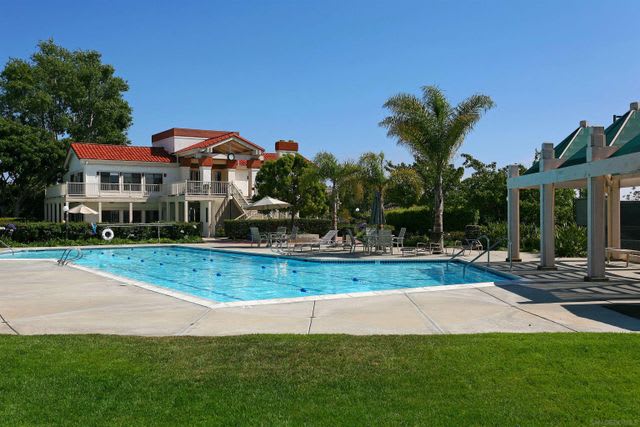 White and brown spacious and luxurious house with a pool and trees