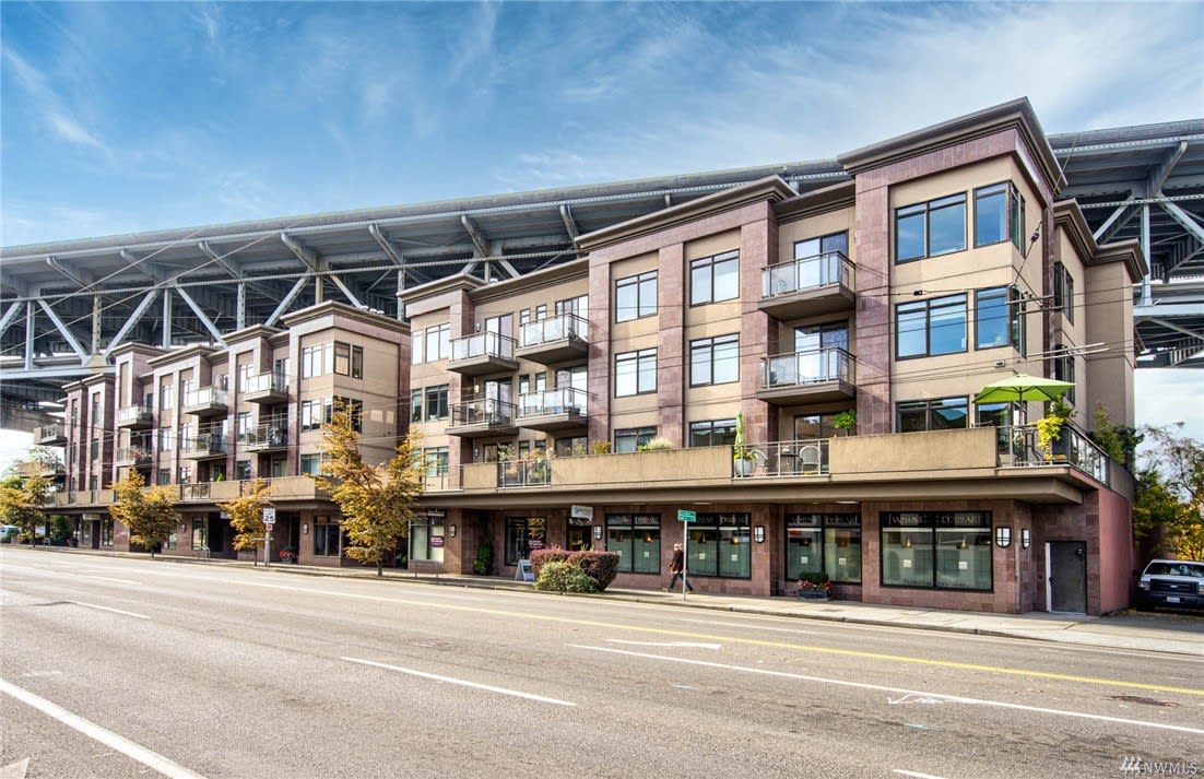 A modern luxury apartment building with a bridge overhead.