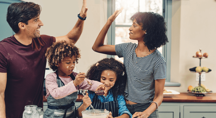 a family of four happily making cookies in their kitchen 