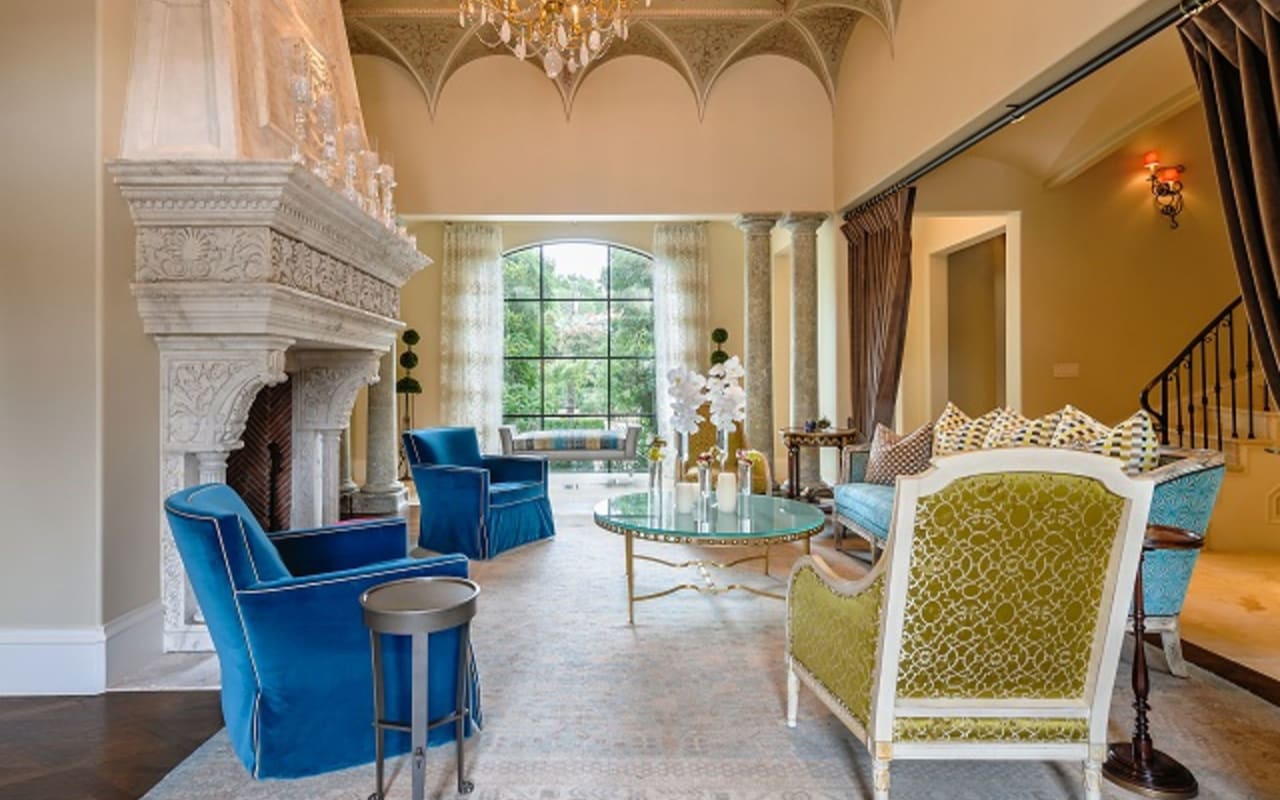 Exquisite living room with stone fireplace, hand-carved ceiling, and columns, exuding elegance and architectural mastery.