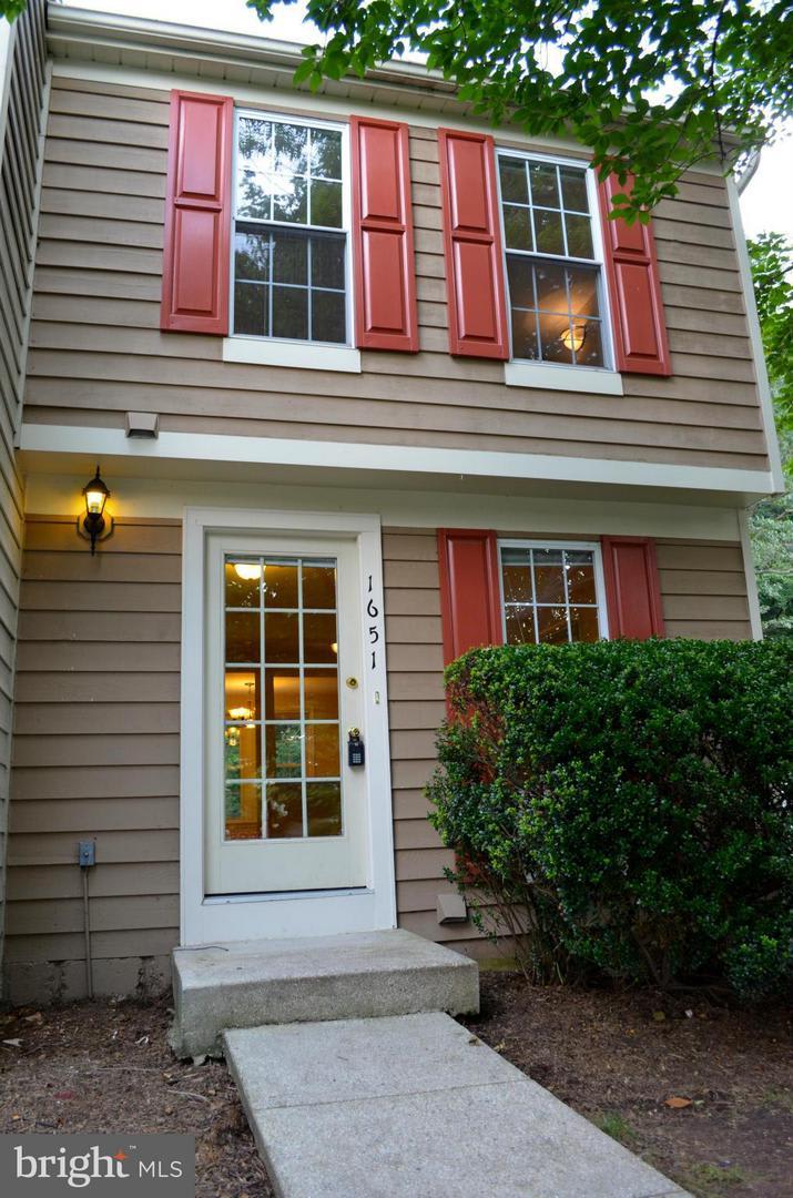 Brown townhouse with red shutters and white front door colonial end unit wood siding