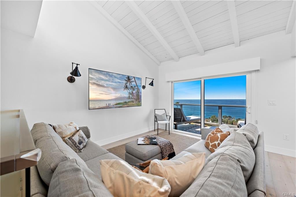 Living room with vaulted ceiling and sliding doors overlooking the ocean.