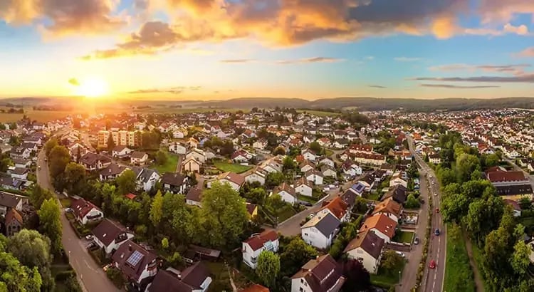 A stunning aerial view of a suburban neighborhood at sunset, with warm, golden hues in the sky. This image emphasizes the beauty of suburban life and the peacefulness of the evening.