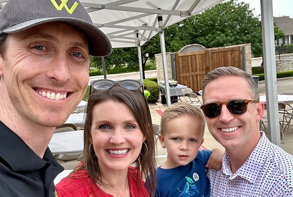 A woman, two men, and a boy in all smiles under a tent