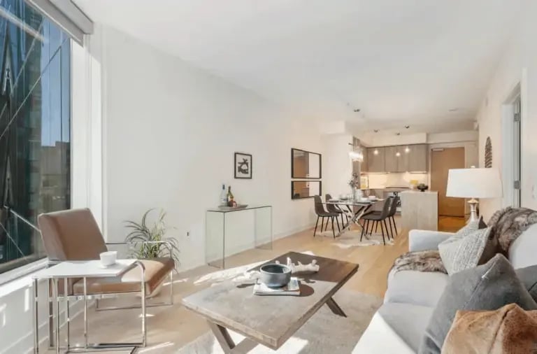Interior of a modern apartment or condo featuring an open-concept living area with a partial view of the kitchen and dining space, designed with contemporary finishes.