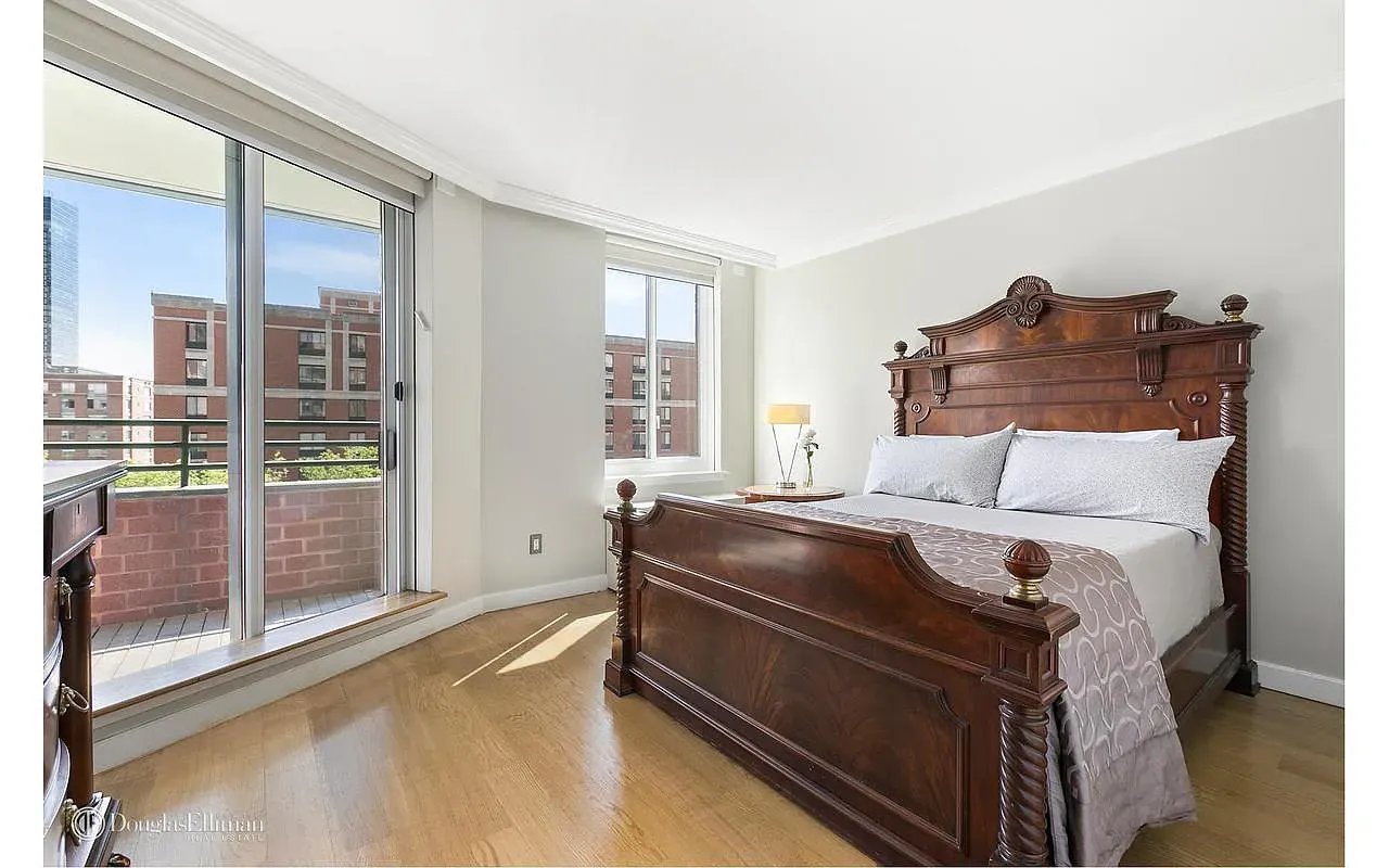 Bedroom with an ornate dark wood bed and sliding glass doors to a balcony.