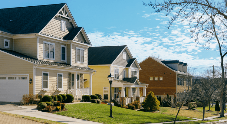 A row of suburban houses with a clear sky in the background.