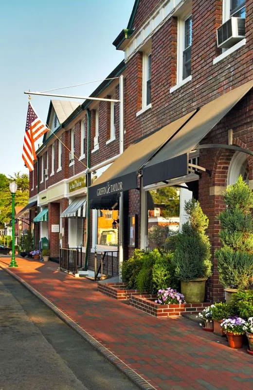 Quaint brick-lined street with boutique shops, exuding the charm of a vibrant, upscale neighborhood.