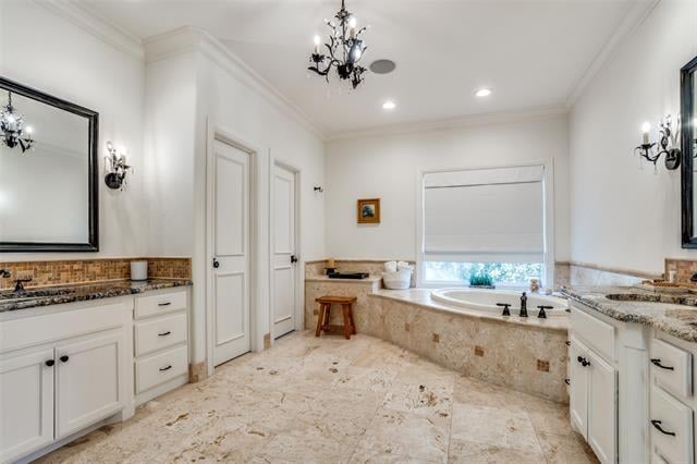 Spacious bathroom with a built-in tub beneath a window and marble flooring.