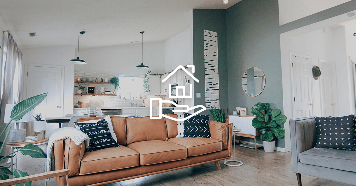 Open-plan living room and kitchen with a brown leather sofa and teal accent wall.