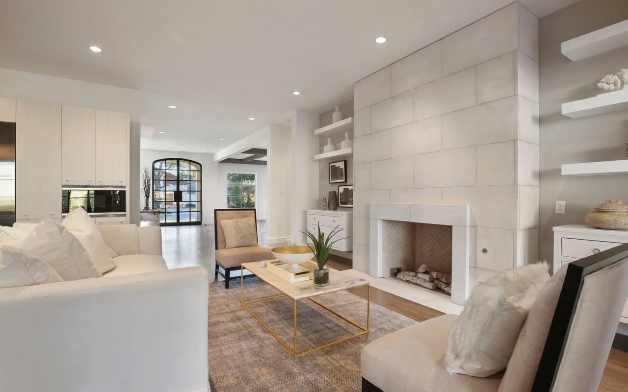 Welcoming living room with stone fireplace and shelves, overlooking the foyer and creating a warm and inviting entryway.