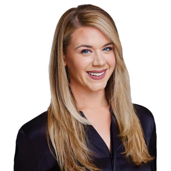 Holly Hughes, smiling real estate agent with long blonde hair in a dark blouse.