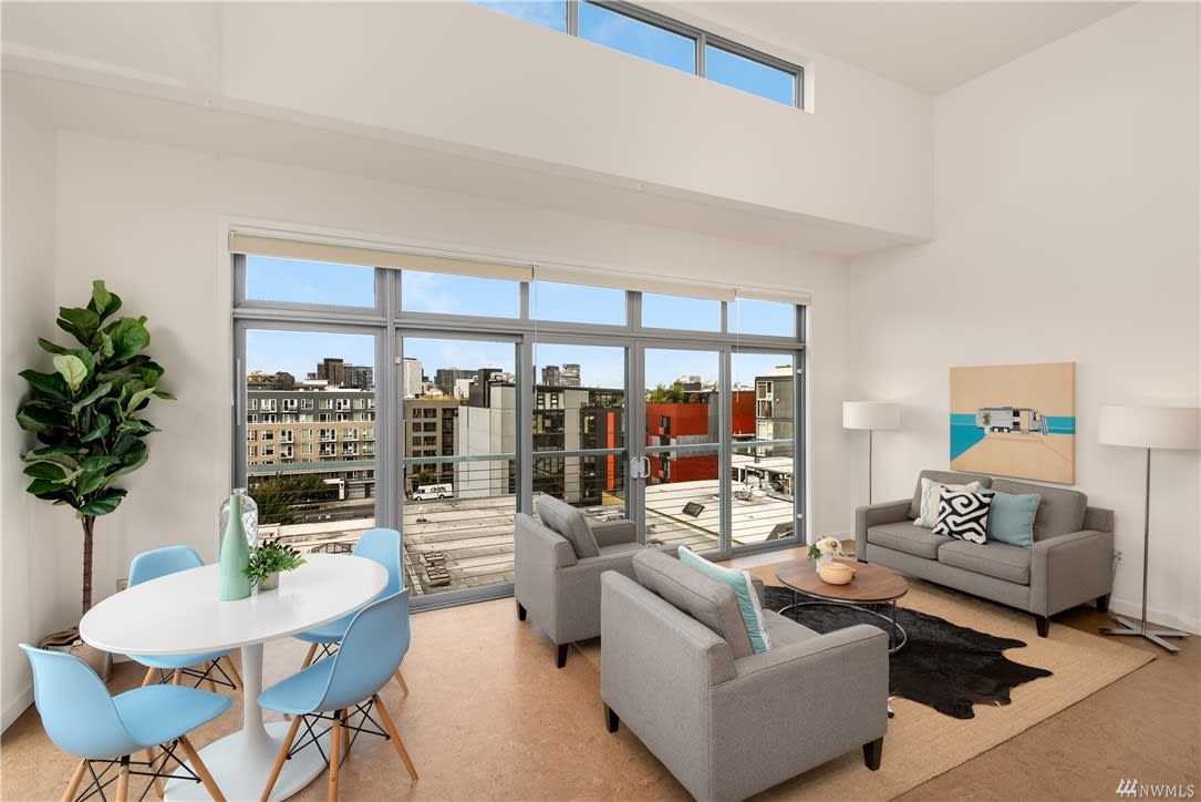 Airy urban condo featuring high ceilings, large windows, and a comfortable living space.