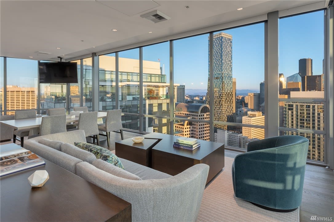 Relaxed living room in a high-rise condo with a couch, chairs, and a dining table.