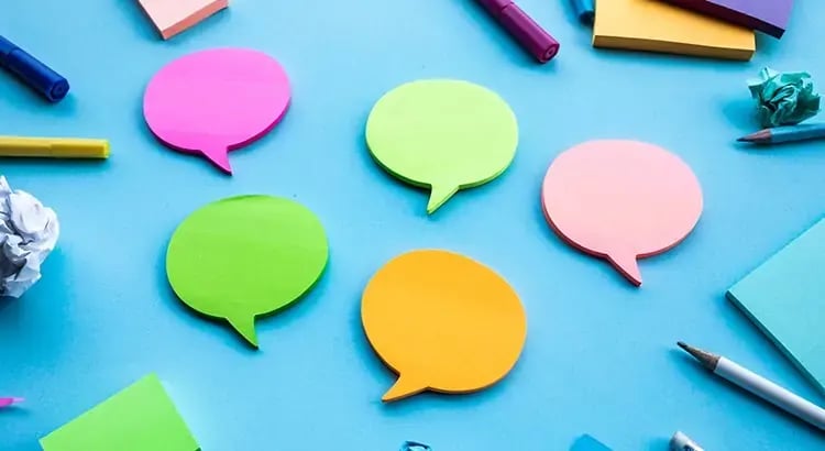 Brightly colored speech bubbles in green, blue, pink, and yellow on a blue background.