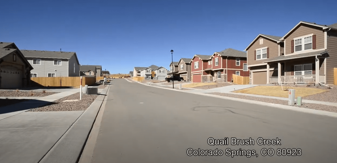 Quail Brush Creek residential street with two-story homes and dry landscaped yards.