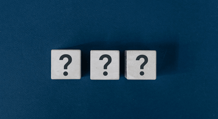 three white blocks on a blue surface with a question mark imprinted on them