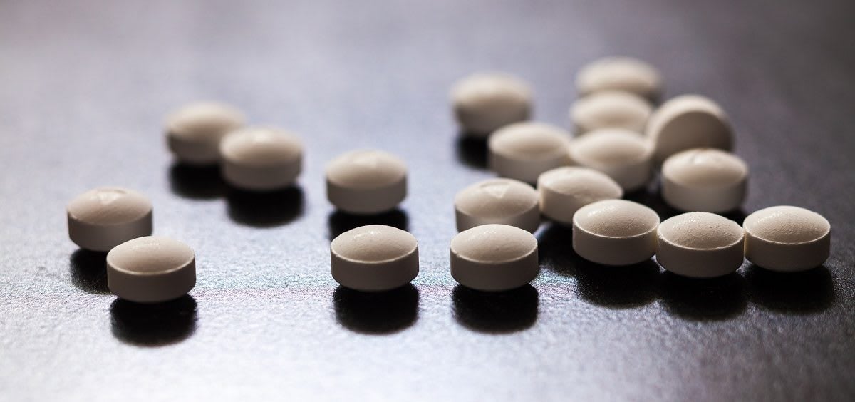 A stack of white pills on a black table