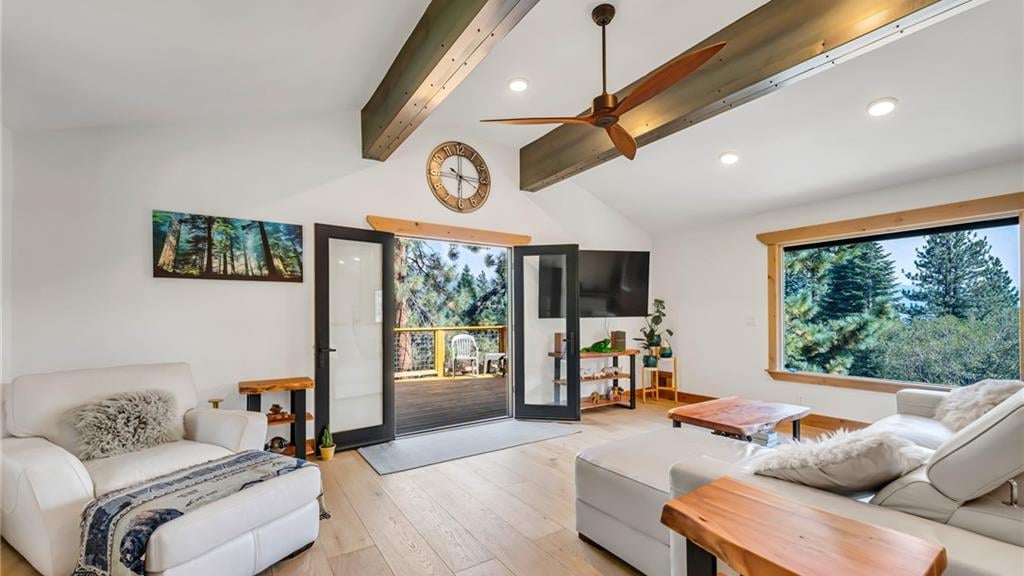 Bright great room with a vaulted white ceiling, exposed beams, wide-plank oak floors and glass doors opening to a deck in the pines at 786 Randall Avenue, Jennifer, Incline Village