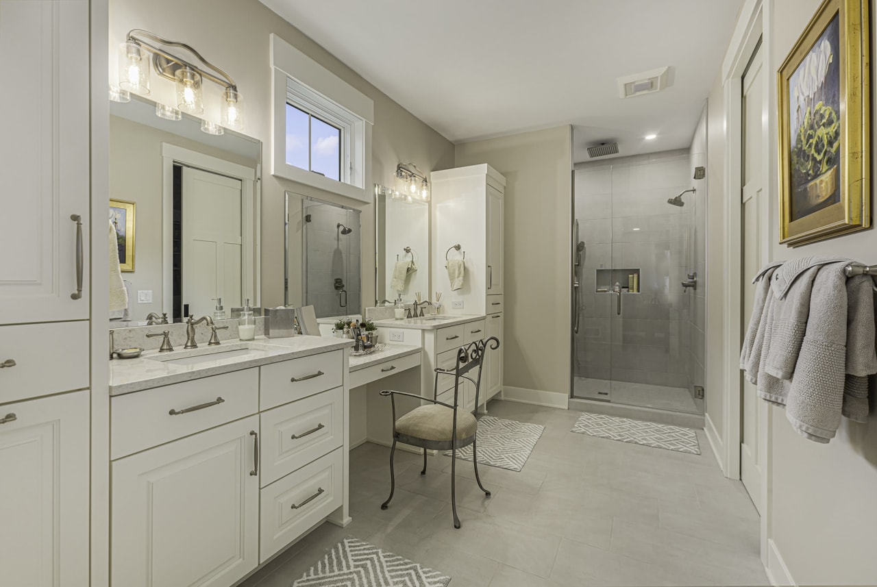 A bathroom with a vanity, mirror, and shower