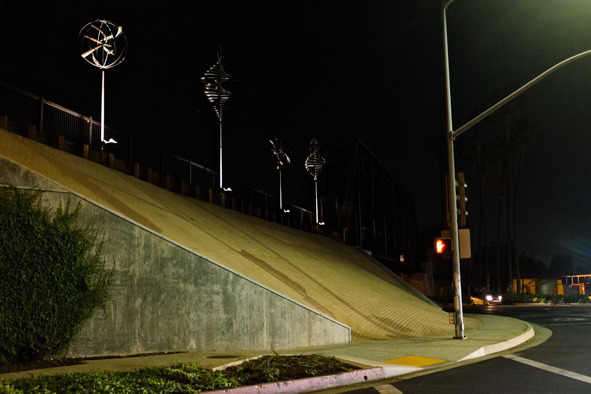 Wind sculptures illuminated above the Whittier Greenway at night