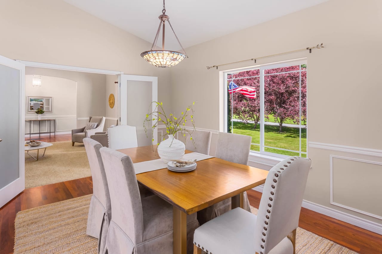 A bright and airy dining room with a wooden table and chairs