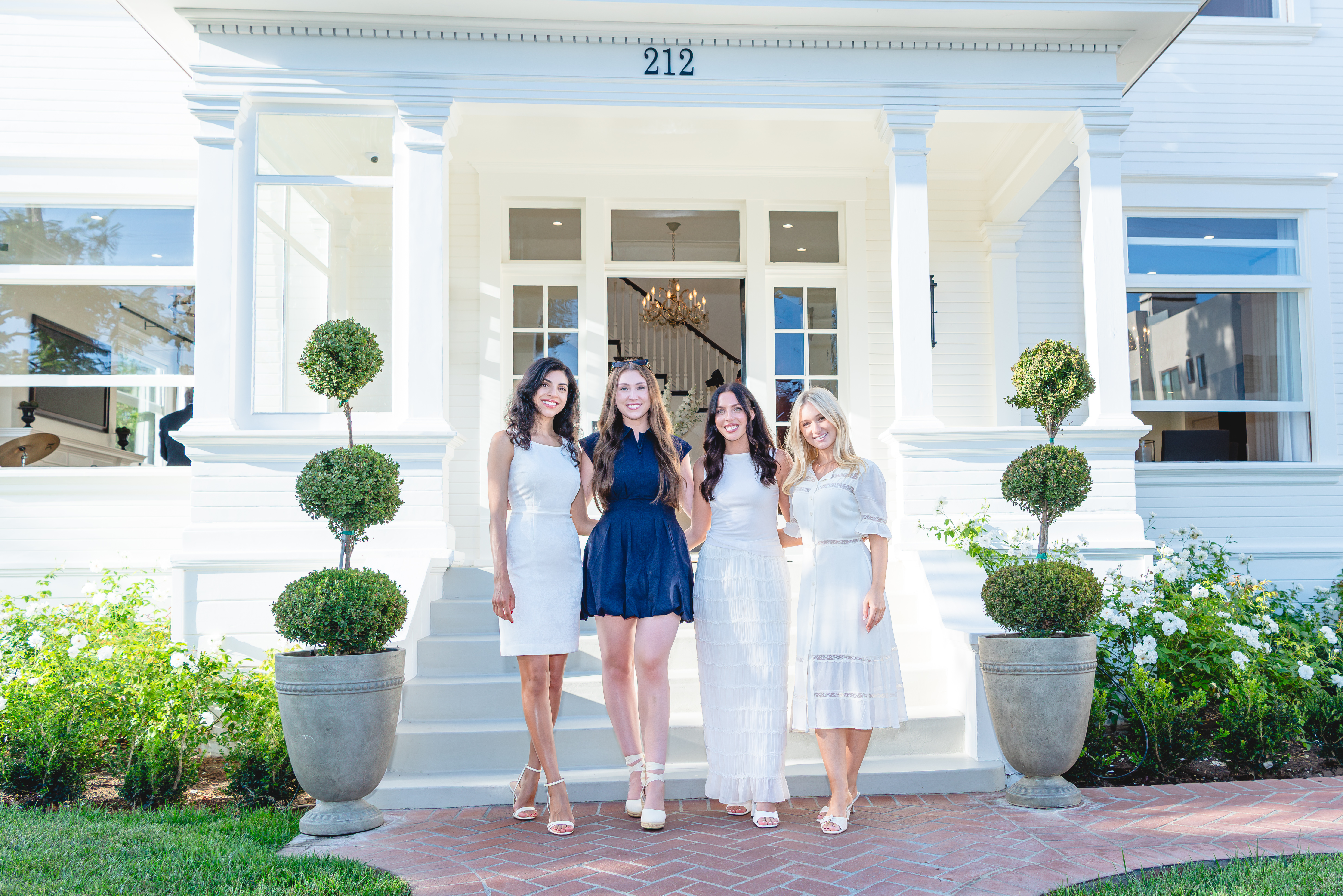 Four guests on the front steps of The Mansion