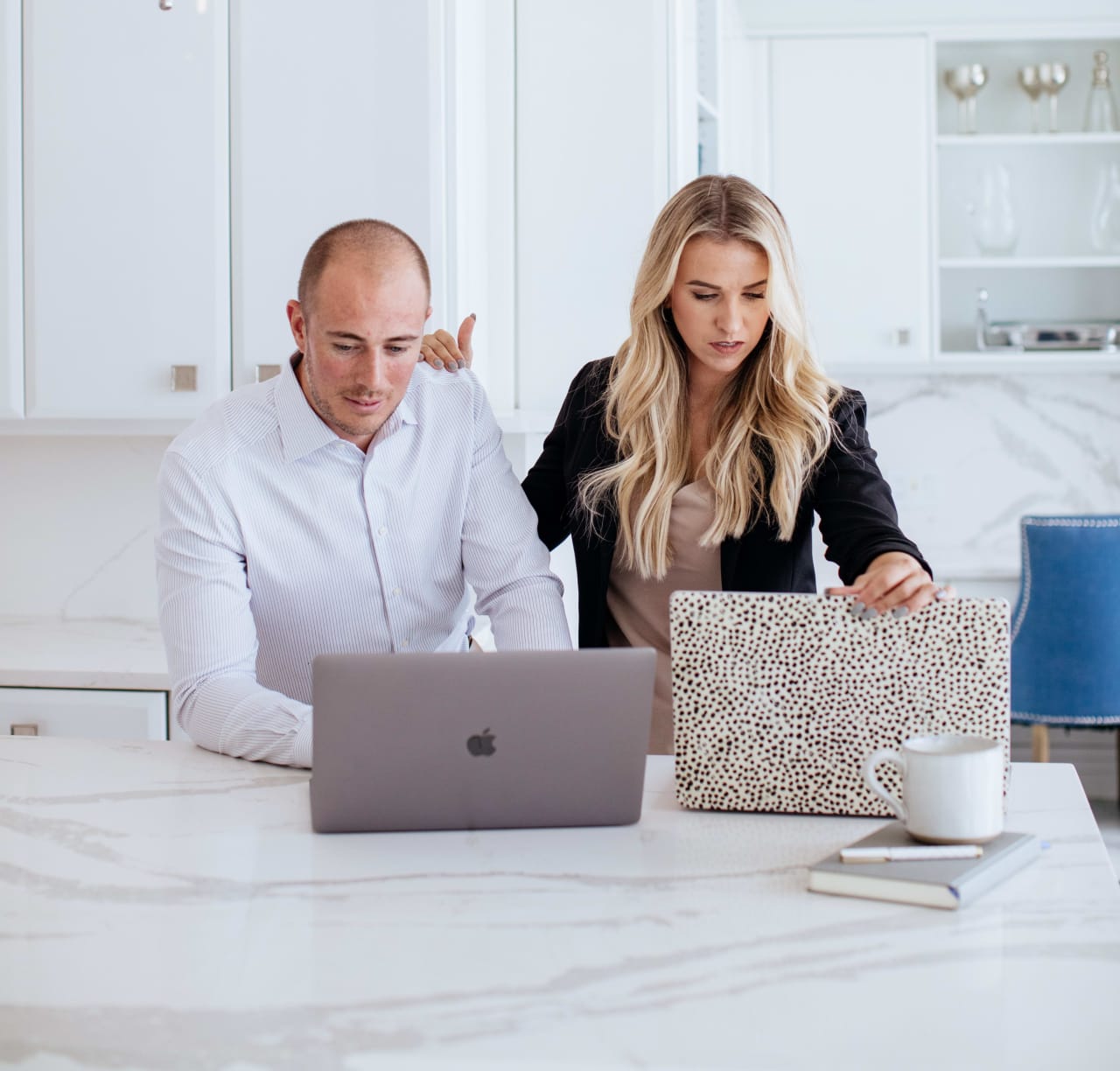 A photo of Theresa Skrzypkowski and Ryan Skrzypkowski working at a kitchen island.