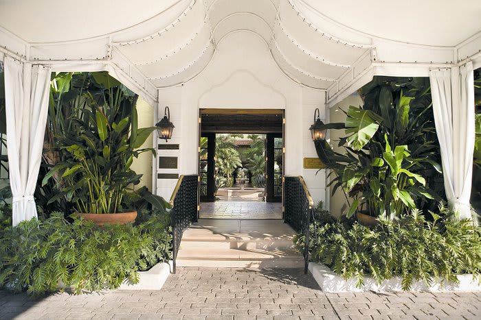 Iconic entrance of Brazilian Court Hotel in Palm Beach with lush green landscaping