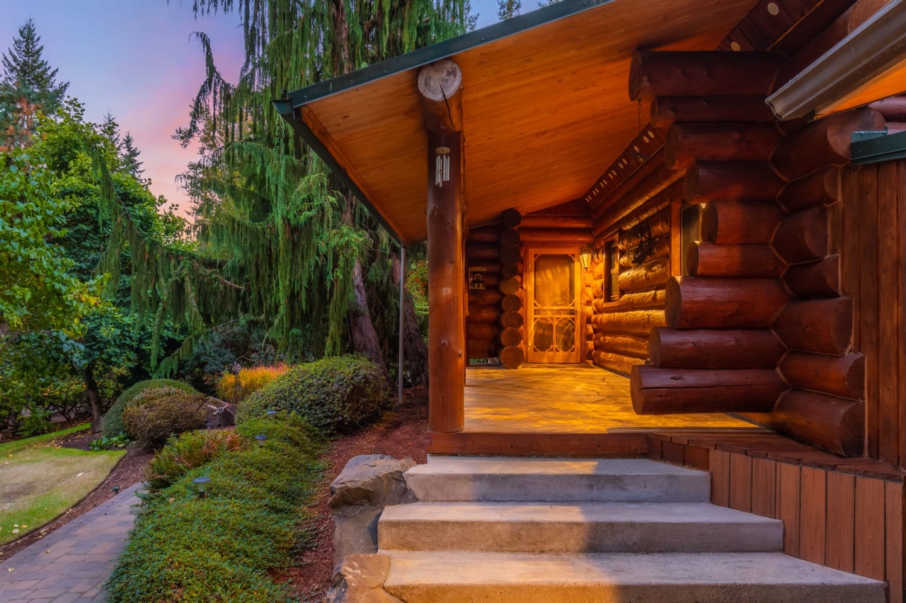 A cozy log cabin with a wooden porch and steps leading up to the entrance