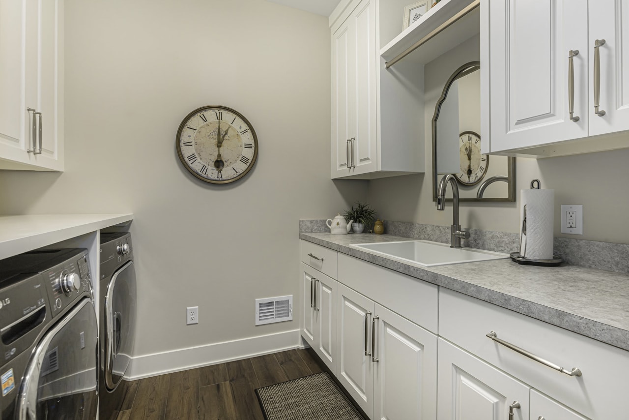 laundry area with sink and white cabinets