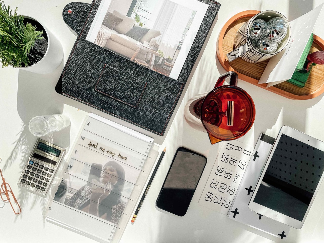 Real estate planning flat lay with a living room on a tablet and “find my way home” on a planner.