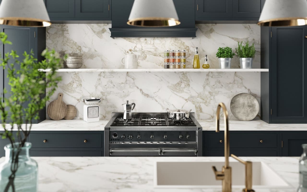 A modern kitchen with dark blue cabinets, a large marble countertop