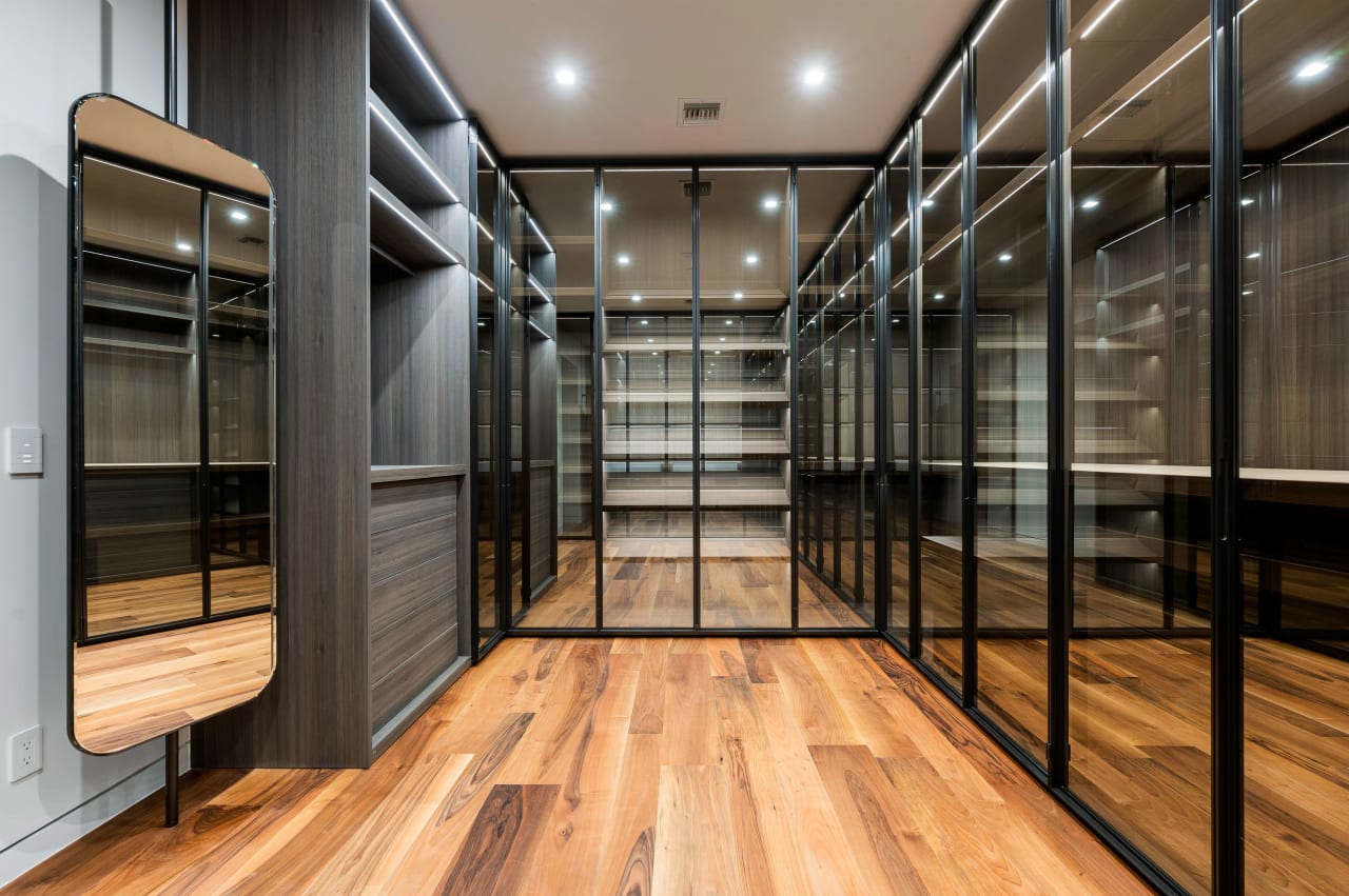 All glass closet with light and dark wood features