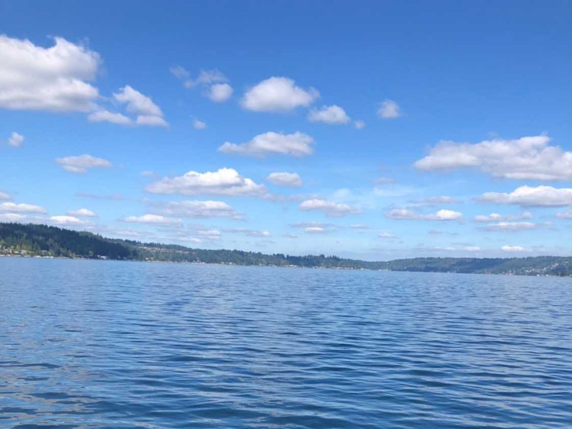 A large body of water with a lot of clouds in the sky