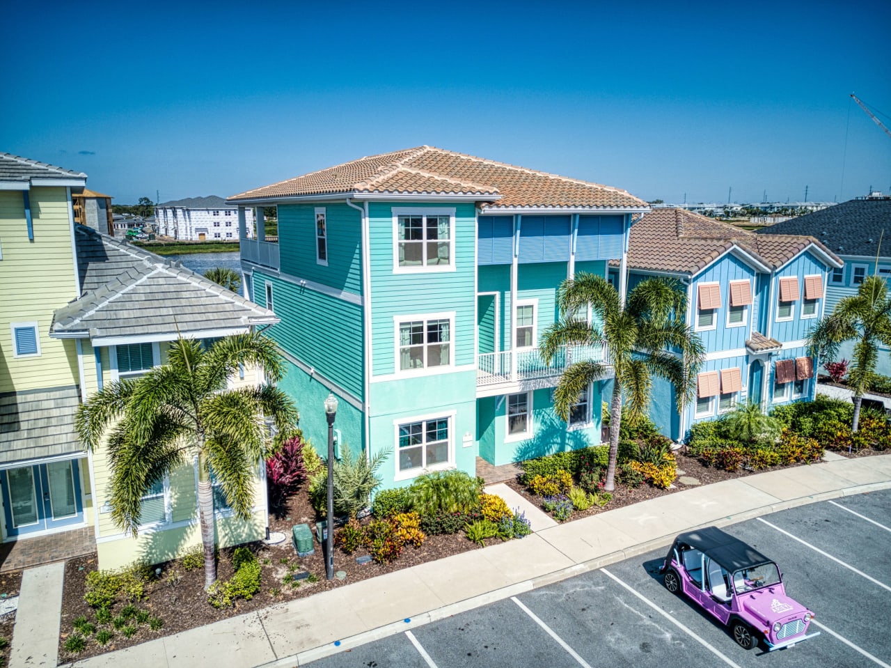 A colorful house with a pink golf cart parked in front of it. 