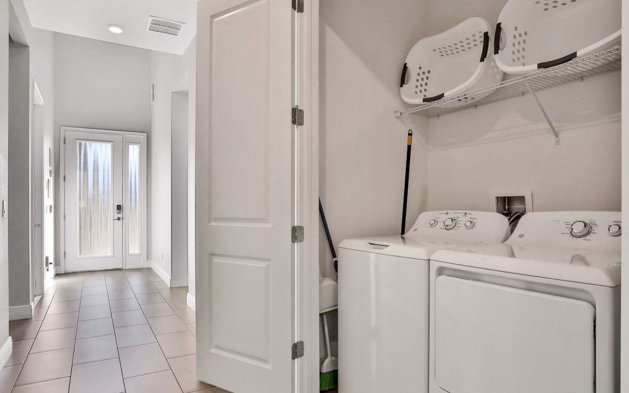 A laundry closet with a white washer and dryer stacked on top of each other.