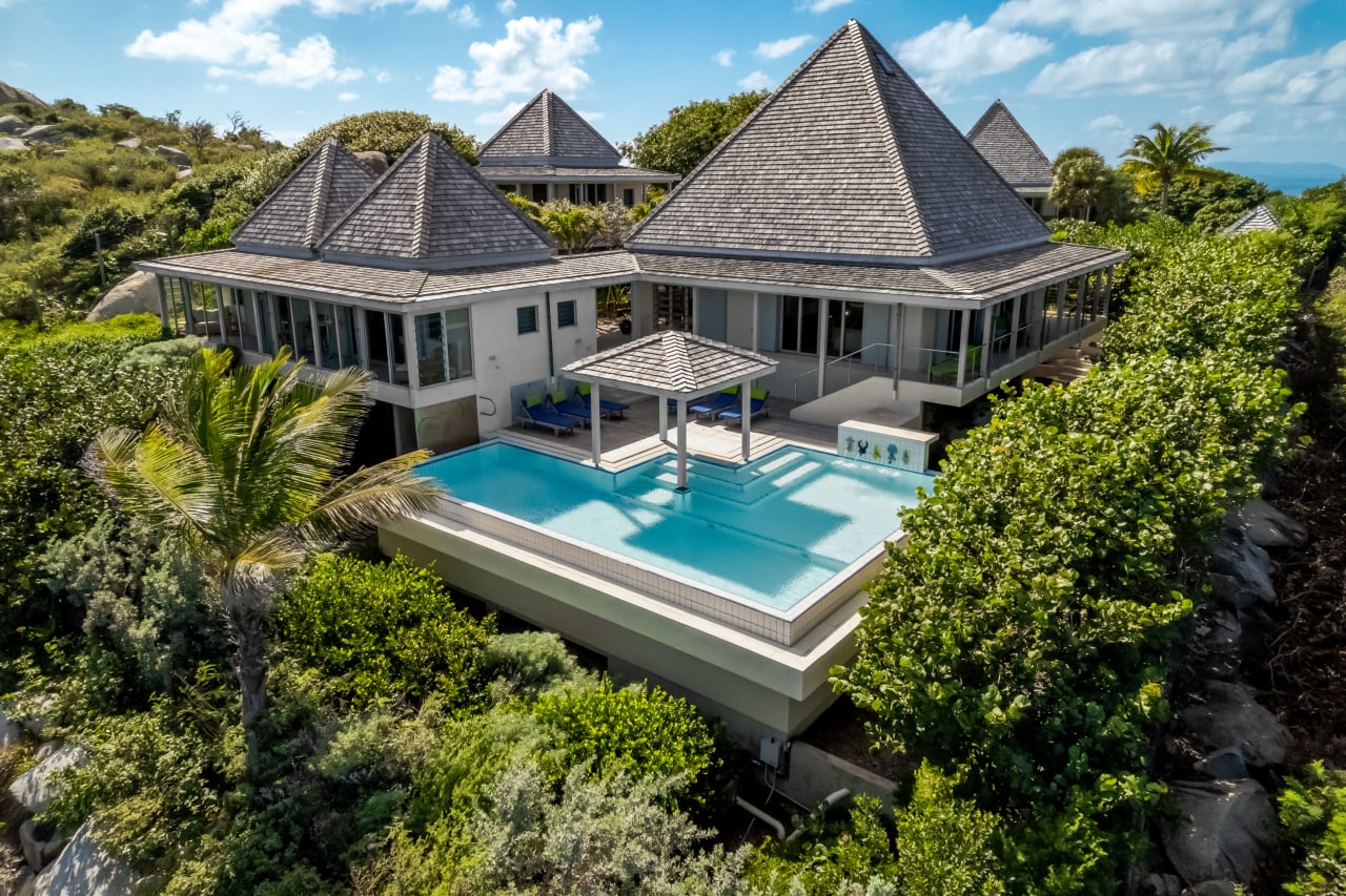 An aerial view of a luxury villa with a large, rectangular swimming pool