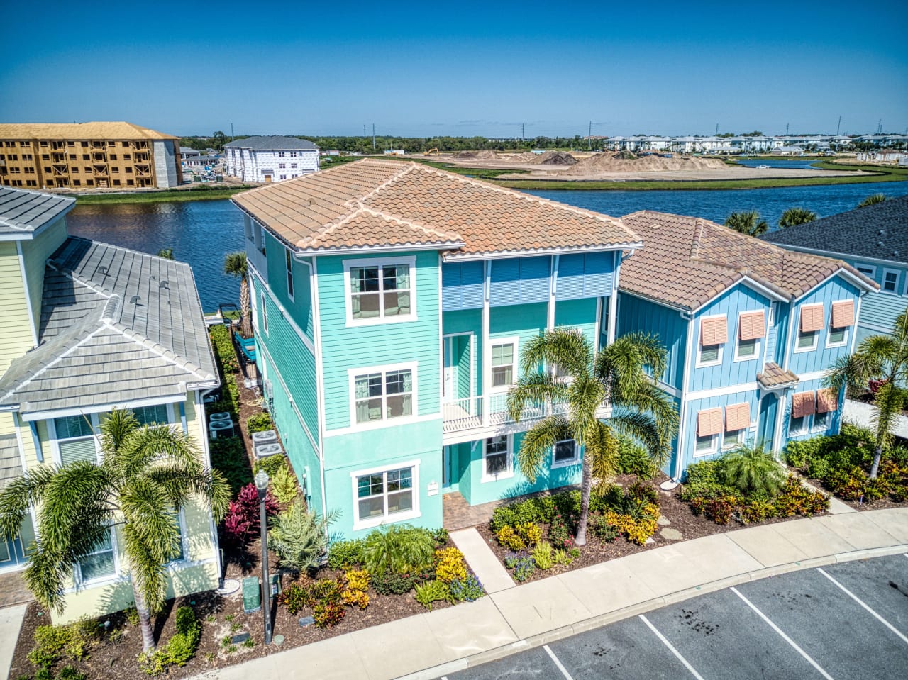 A colorful house with a bright pink roof and a turquoise exterior.