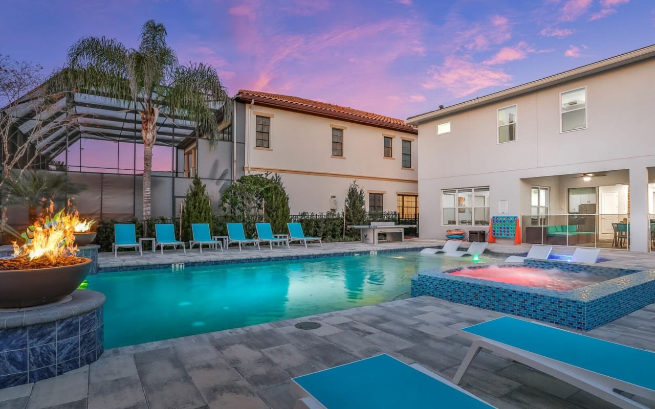 A luxurious outdoor space with a large swimming pool and a fire pit.