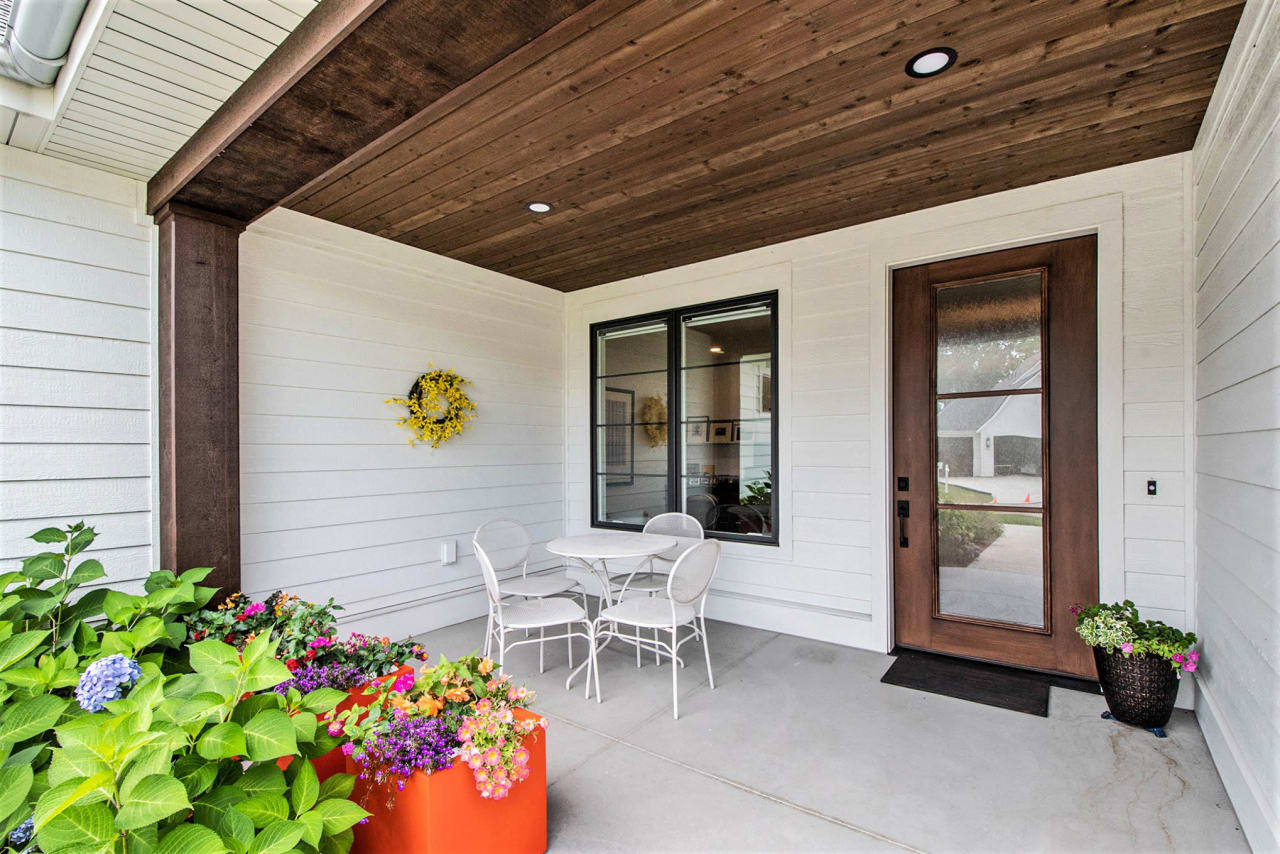 front porch of a house with tables and chairs