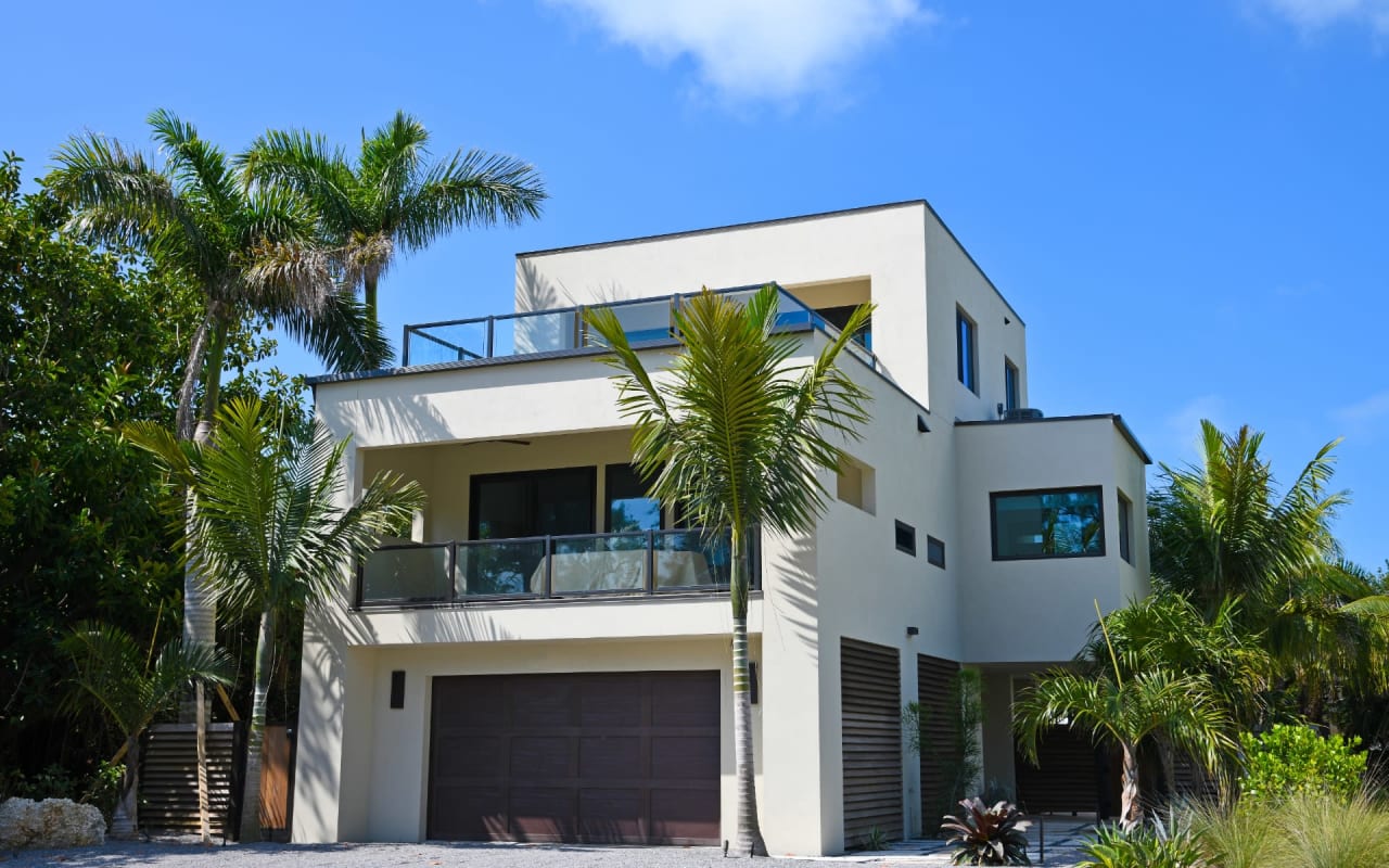 A large white house with a garage and a balcony.