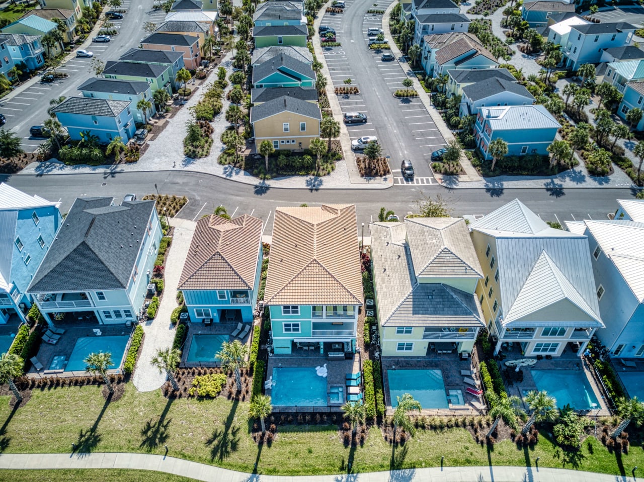 An aerial view of a suburban neighborhood with a row of houses in various shapes and sizes.