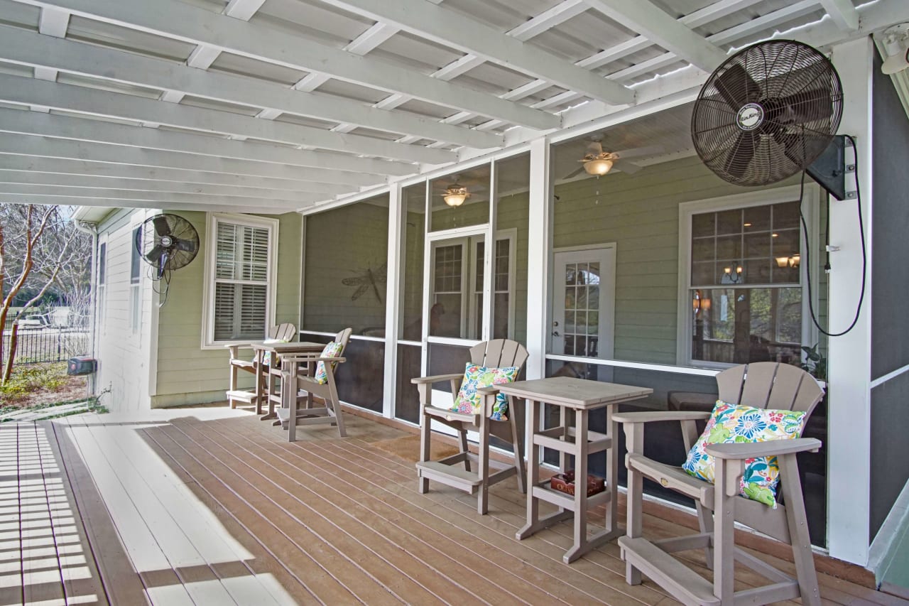 A covered porch with outdoor seating and a ceiling fan, providing a comfortable outdoor living space.