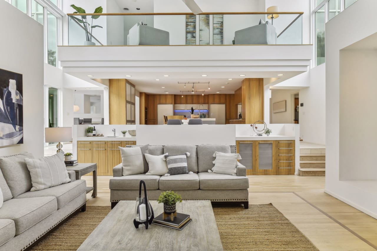 A living room with a couch, coffee table, and a glimpse of a kitchen in the background.