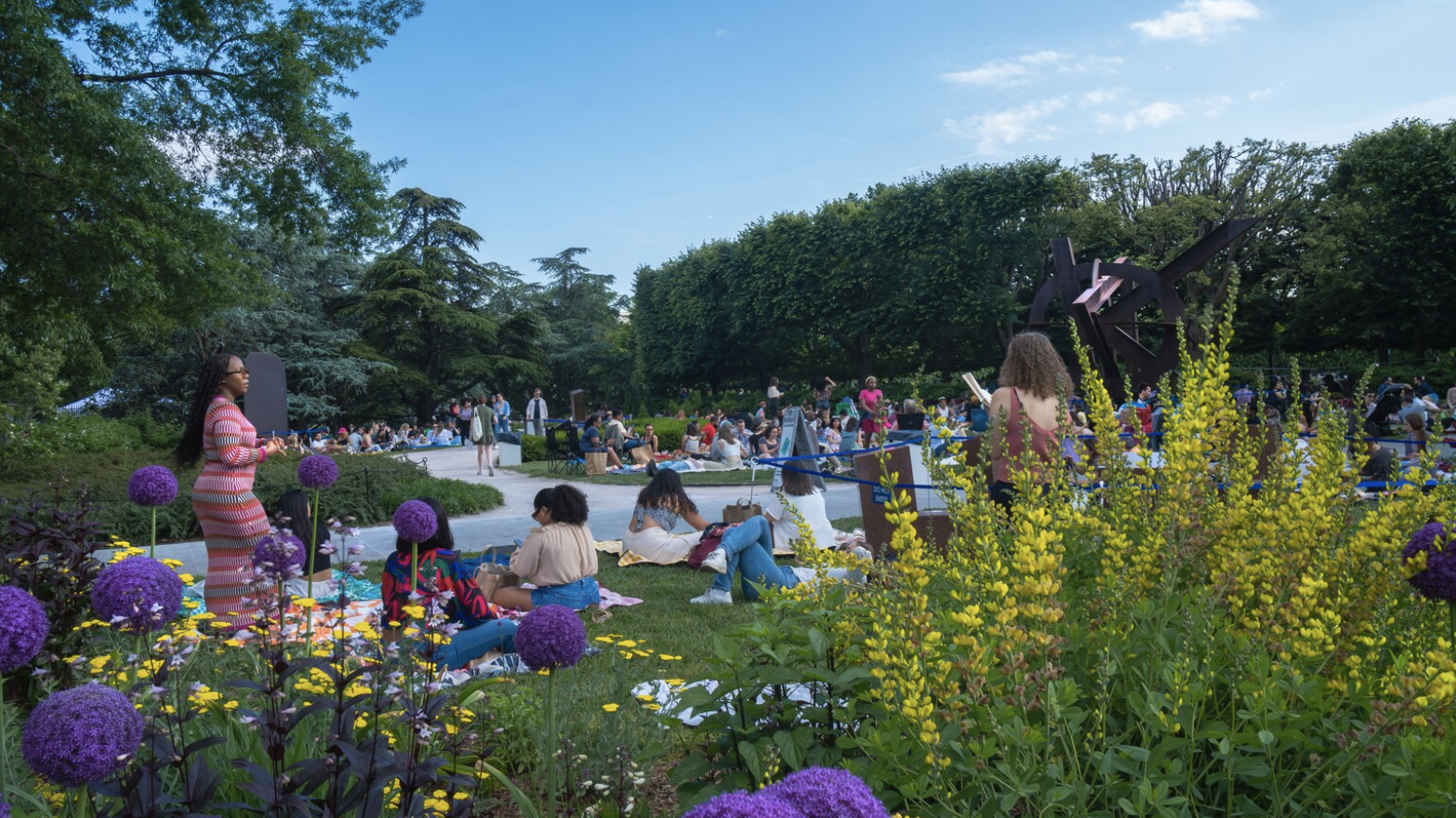 Visitors picnicking among summer flowers at Jazz in the Garden, NGA Sculpture Garden, Washington DC