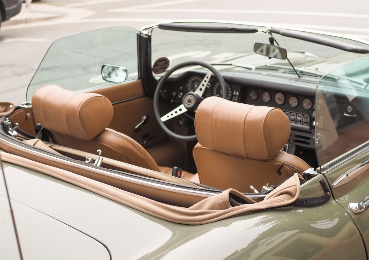 A green convertible sports car parked on the side of the road